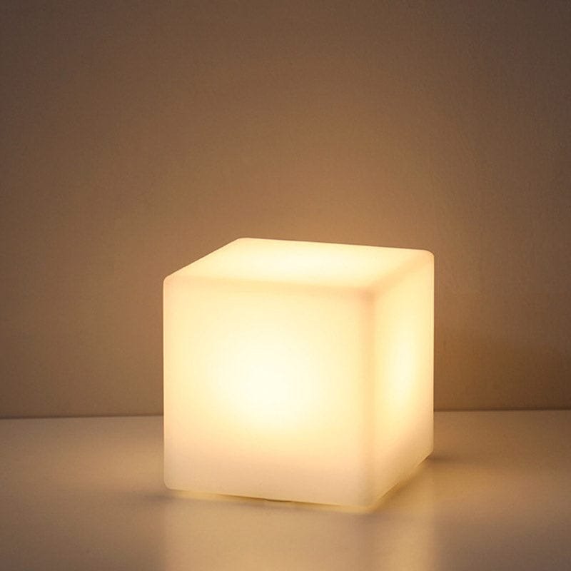 Cube Veilleuse : Luminothérapie Douce pour Bébé et Parents 1 Cube veilleuse qui brille sur une petite table