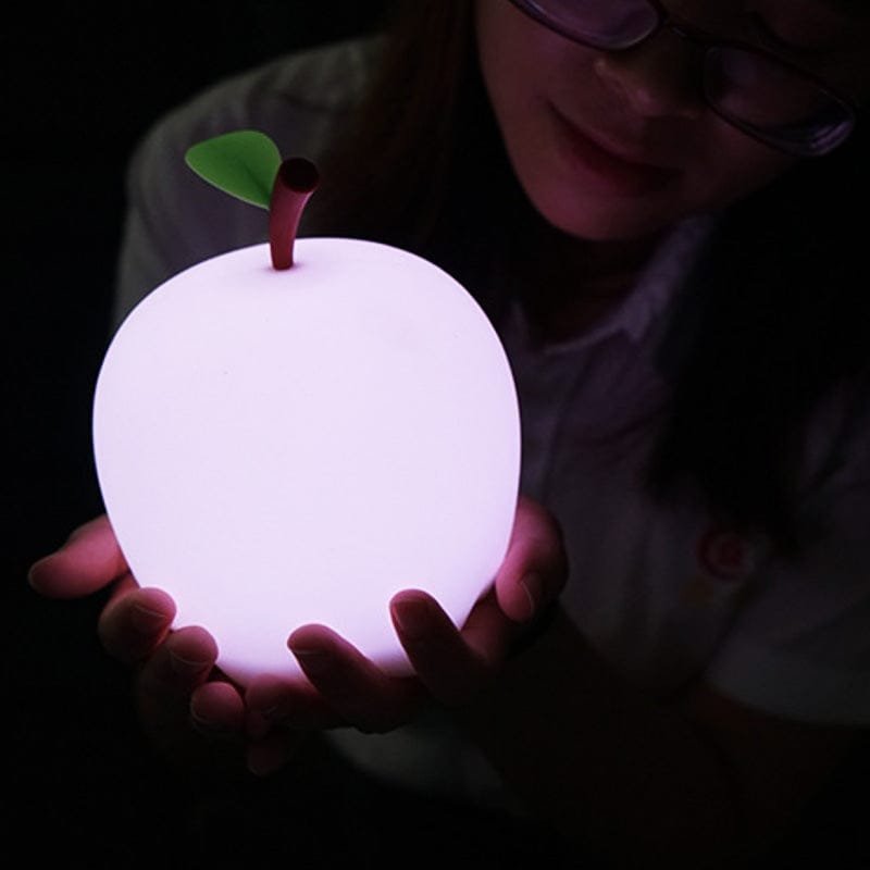 Femme qui tient la veilleuse pomme dans ses mains