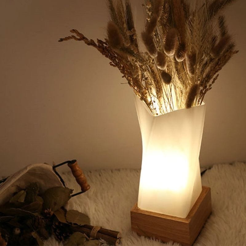 lampe de chevet bois design allumée avec des fleur à l'intérieur